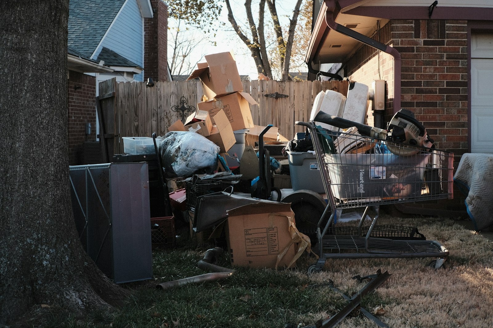 A collection of household junk and boxes piled up in a residential driveway.